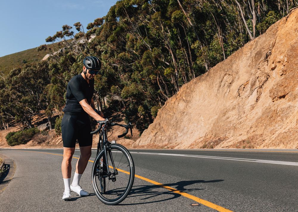 Man walking with bicycle on road