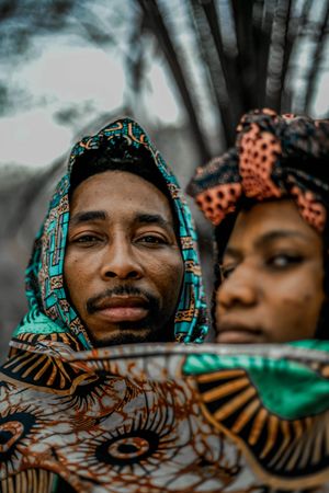 Man and woman covering themselves with brown and blue scarf