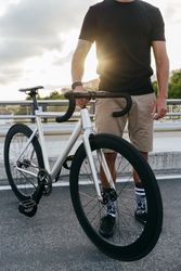 Man with bike standing on bridge