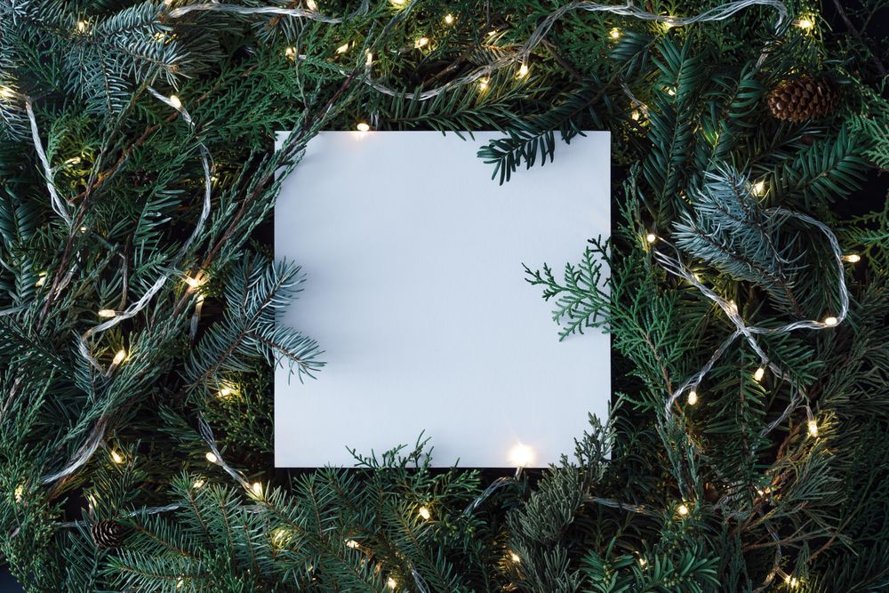 Christmas tree branches with lights and paper card note