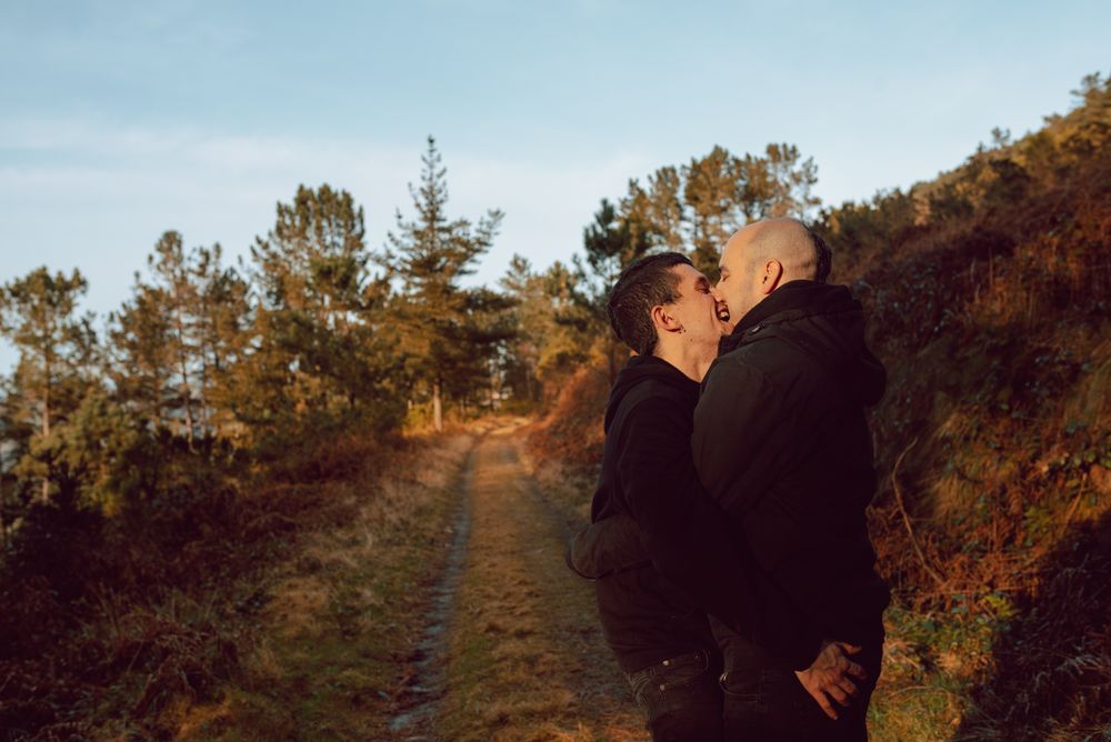 Smiling men hugging on countryside road