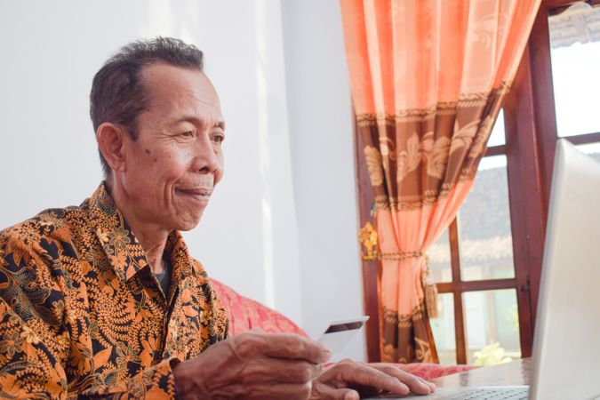 Older male doing payment online with credit card