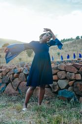 Woman poses while extending her arm and bending the other
