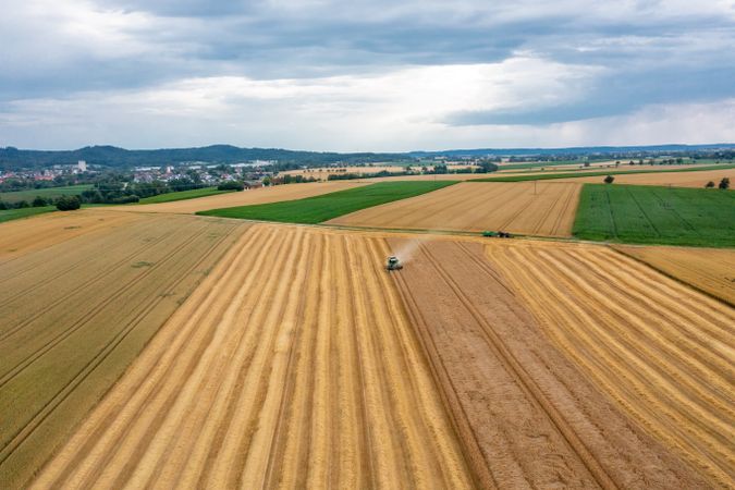 Aerial image with a combine harvesting crop in Germany in the evening