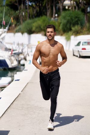 Male exercising on waterfront, vertical