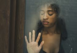 Black female touching wet window