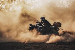 Person with helmet riding an ATV