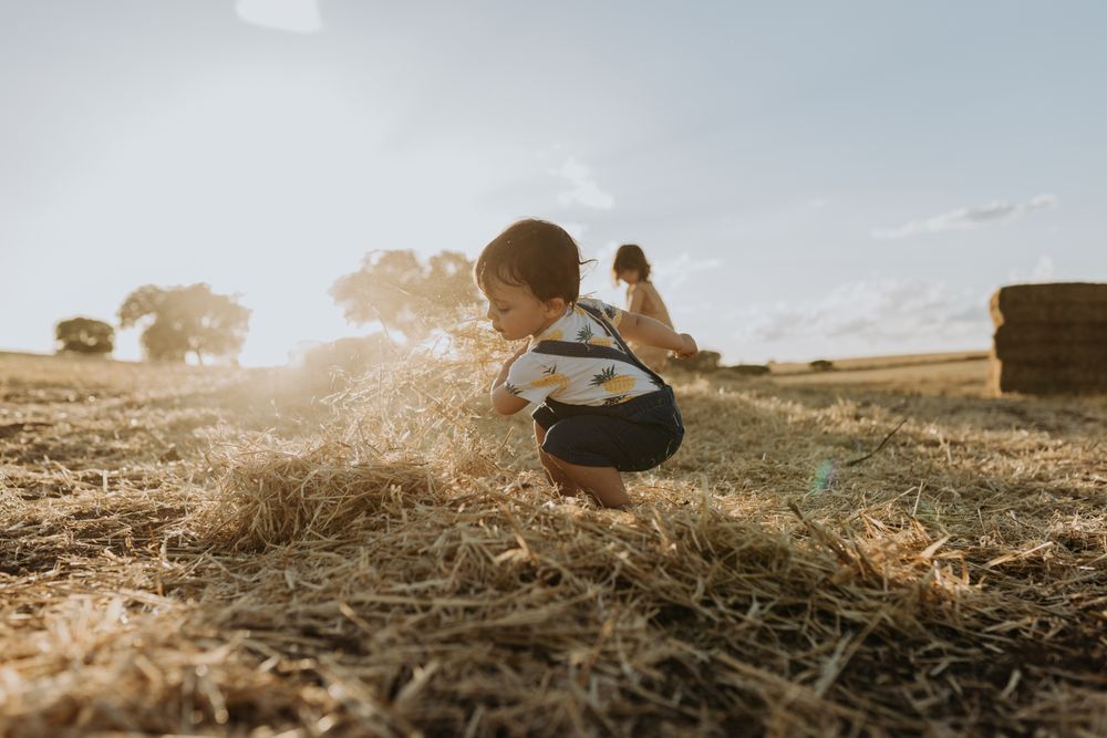 Little boy crouching in the hay
