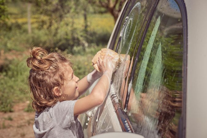 Little boy washing car on sunny day