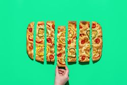 Sliced focaccia isolated on a green background, table top view