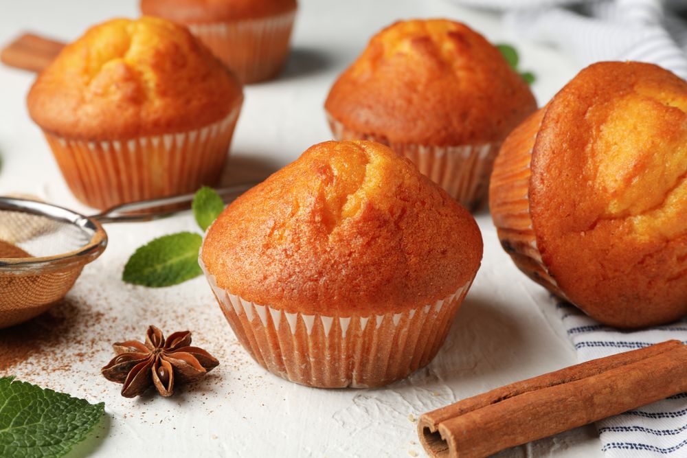 Composition with muffins and cinnamon on light background