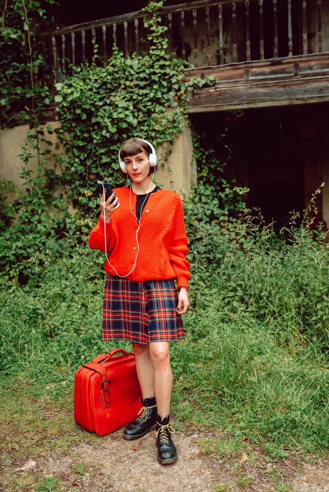 Woman in headphones with suitcase choosing music