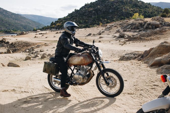 Person on motorcycle in rugged terrain