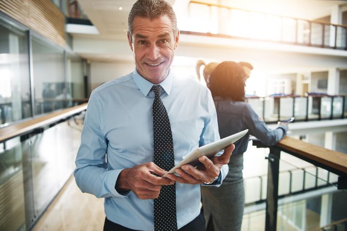 Portrait of businessman smiling with tablet