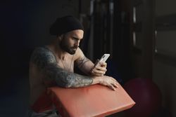 Athlete with smartphone in gym