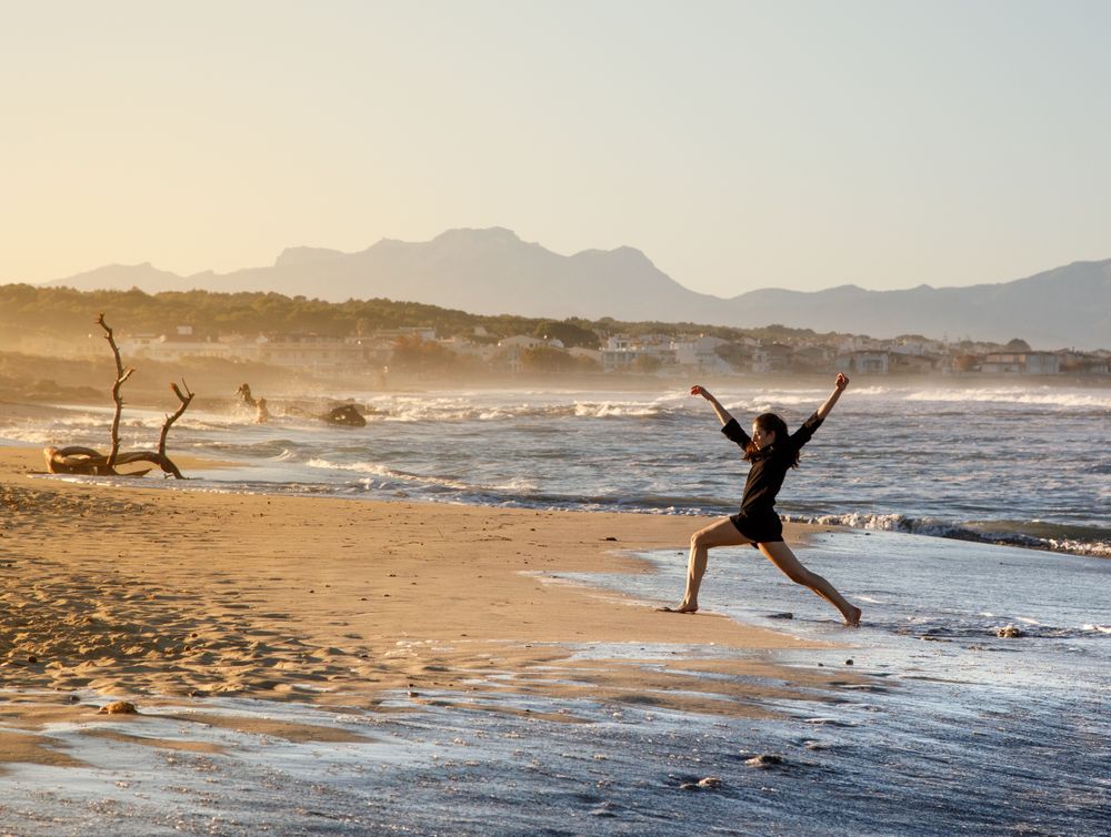 Woman with dancing near water on shore