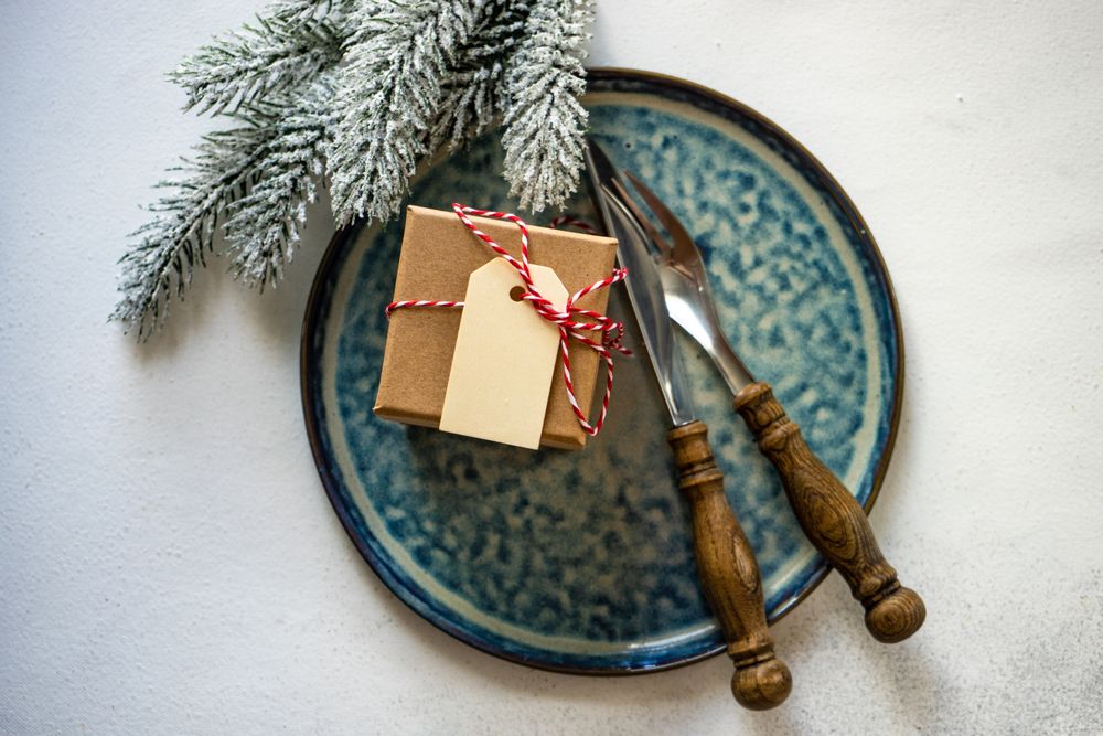 Top view of Christmas table setting of blue plate with gift