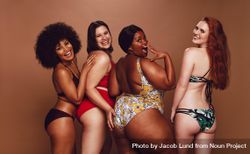 Beautiful group of friends in swimwear posing and looking over the shoulder at camera bGzpY4