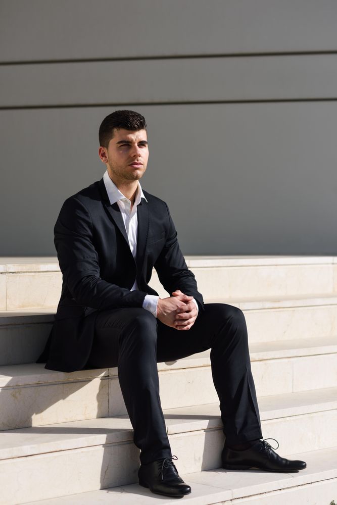 Thoughtful man sitting tall on stairs