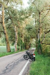 Motorcycle on countryside road near grass
