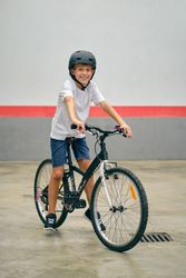 Smiling boy on modern bicycle on parking lot