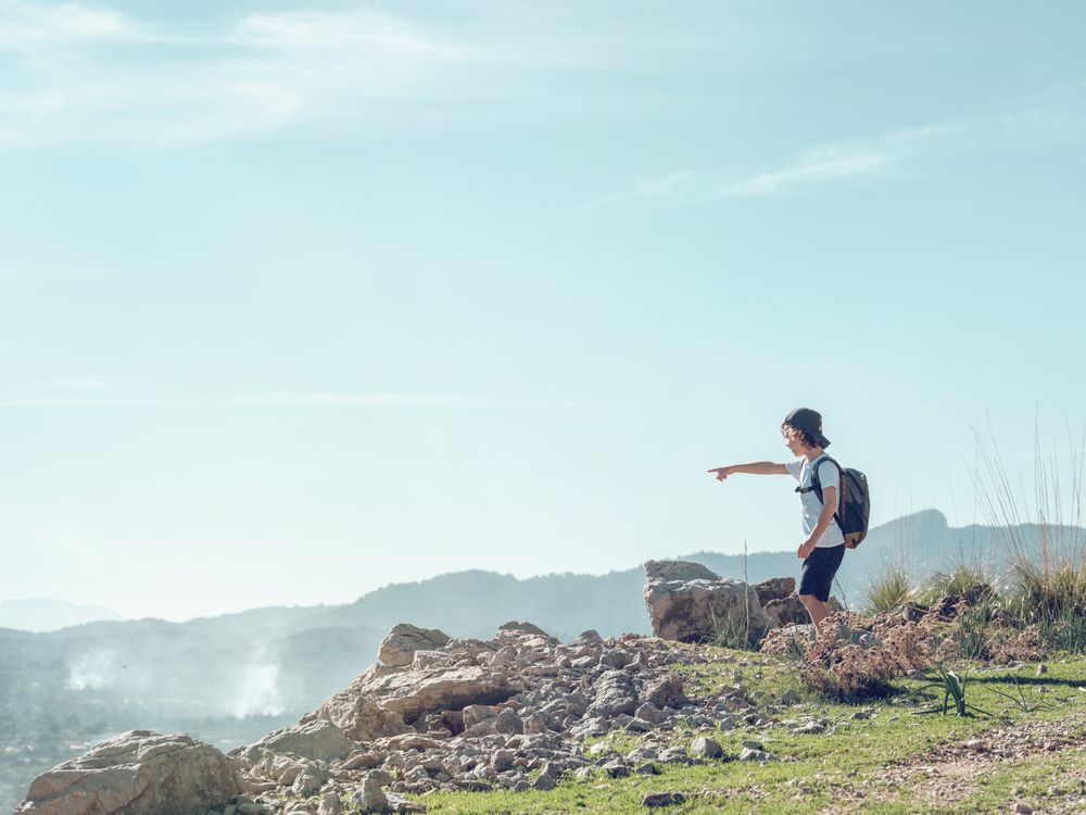 Boy with backpack exploring mountains