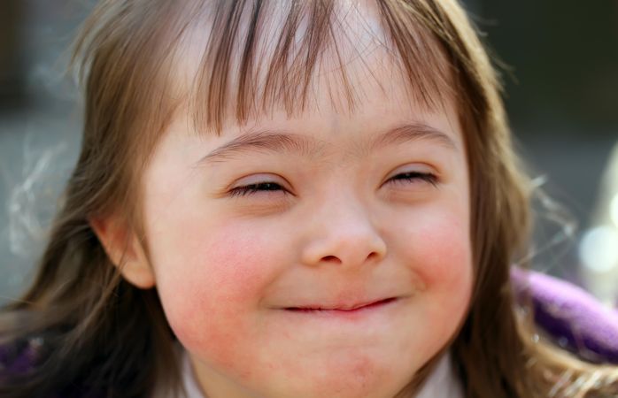 Portrait of young girl with Down syndrome outside on a cold day