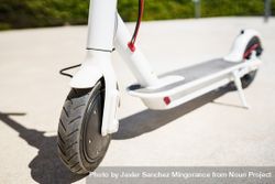 Close up of electric scooter front wheel parked in the sun 0yWe74
