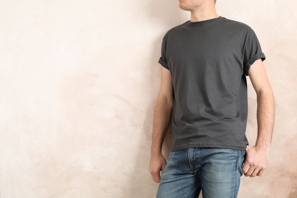 Men in blank grey t-shirt against color background, space for text