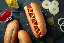 Tasty hot dog and ingredients on wooden background