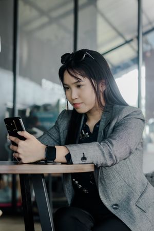 Sophisticated woman checking her smartphone at a modern cafe
