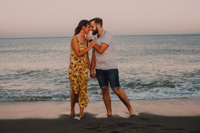 Loving couple embracing happily on sandy beach