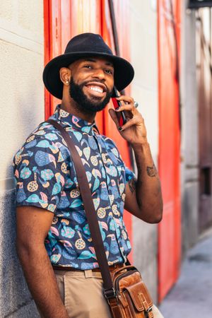 Stylish Black man talking on the phone outdoors in the city