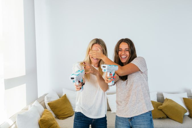 Delighted women playing videogame with light guns