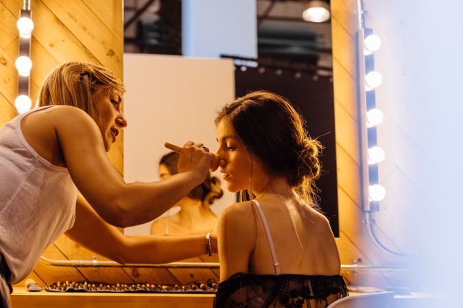 Makeup artist doing makeup for young female artist