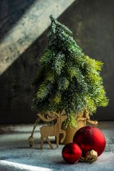 Christmas card concept of mini tree with bauble and reindeer ornament
