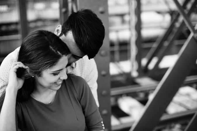 Amorous couple bonding on railway under bridge