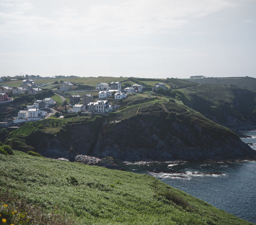 Town on green hill near sea