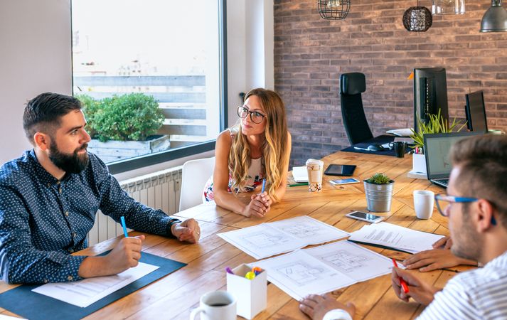 Businesspeople in a work meeting looking at construction drawings