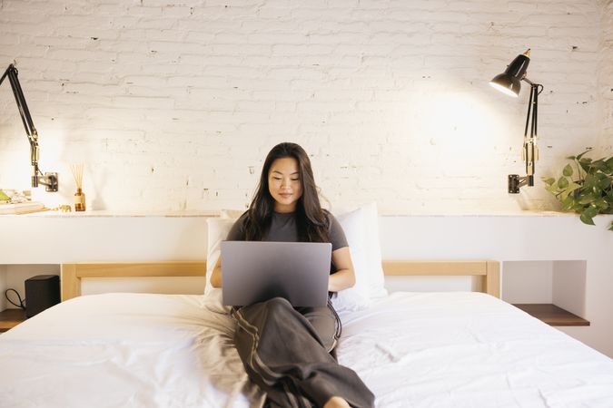 Young woman using a laptop on bed