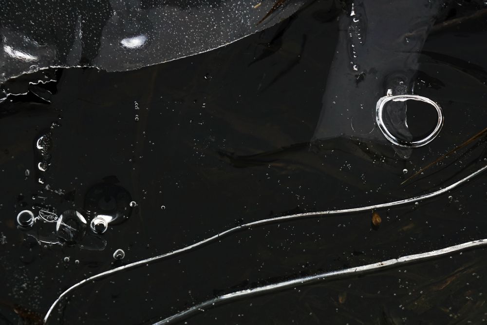 Fragment of thin ice on dark frozen river