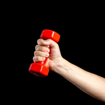 Hand holding a red dumbbell on a dark background.