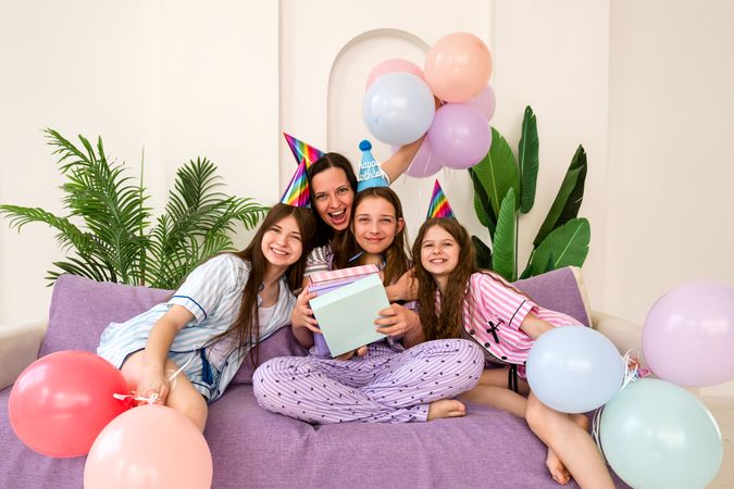 Family posing with presents during birthday celebration at home.