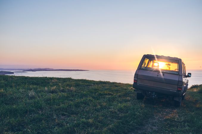 Car on seashore during sunset