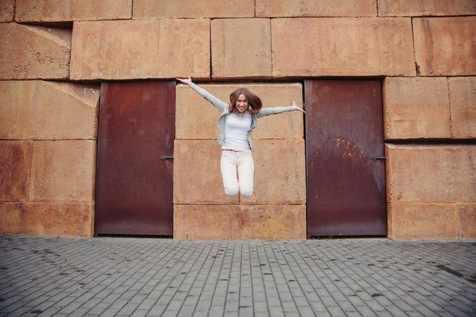 Young woman jumping for joy on street