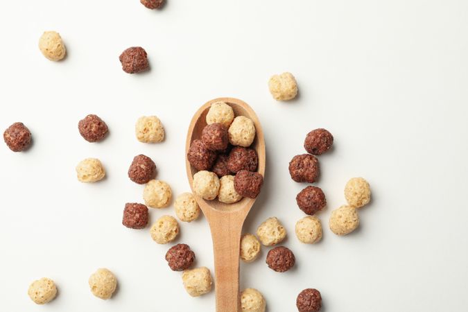 Spoon with corn balls on neutral background