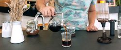 Banner of unrecognizable barista pouring specialty coffee from Japanese siphon coffee maker in glass