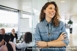 Smiling woman with coworkers in conference room having meeting 5wY11b