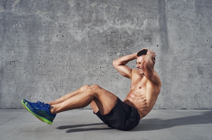 Muscular shirtless man doing ab exercises