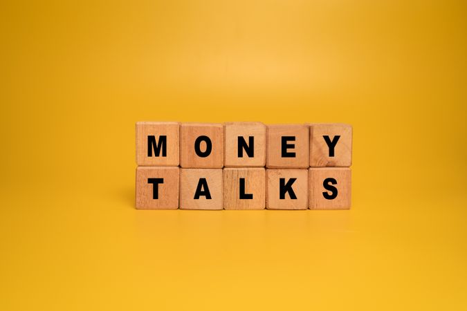 money talks words on wooden blocks isolated on orange background